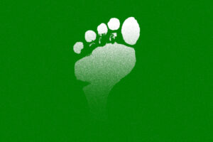 White color human foot print with the green background representing carbon foot print made by human.